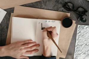 Person writing a to-do list in a notebook, essential for wedding planning and Eisenhower Matrix, featured on Dream Life Space blog.