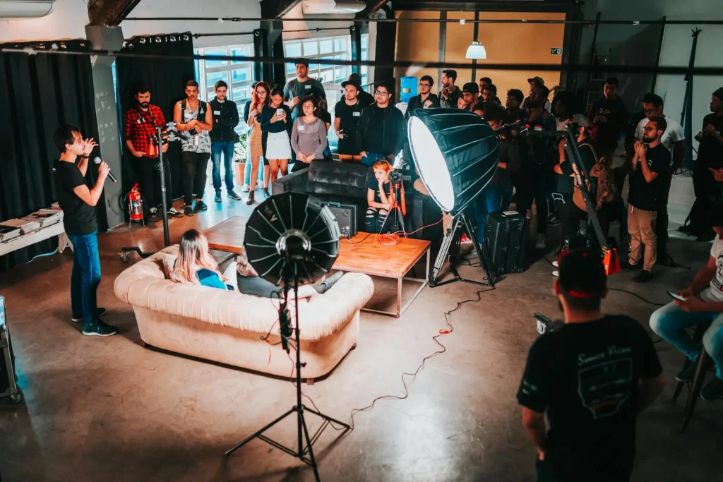 A group of people attending a motivational seminar, with a speaker addressing the audience.