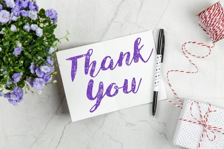 Thank you card with flowers and pen demonstrating the power of gratitude.